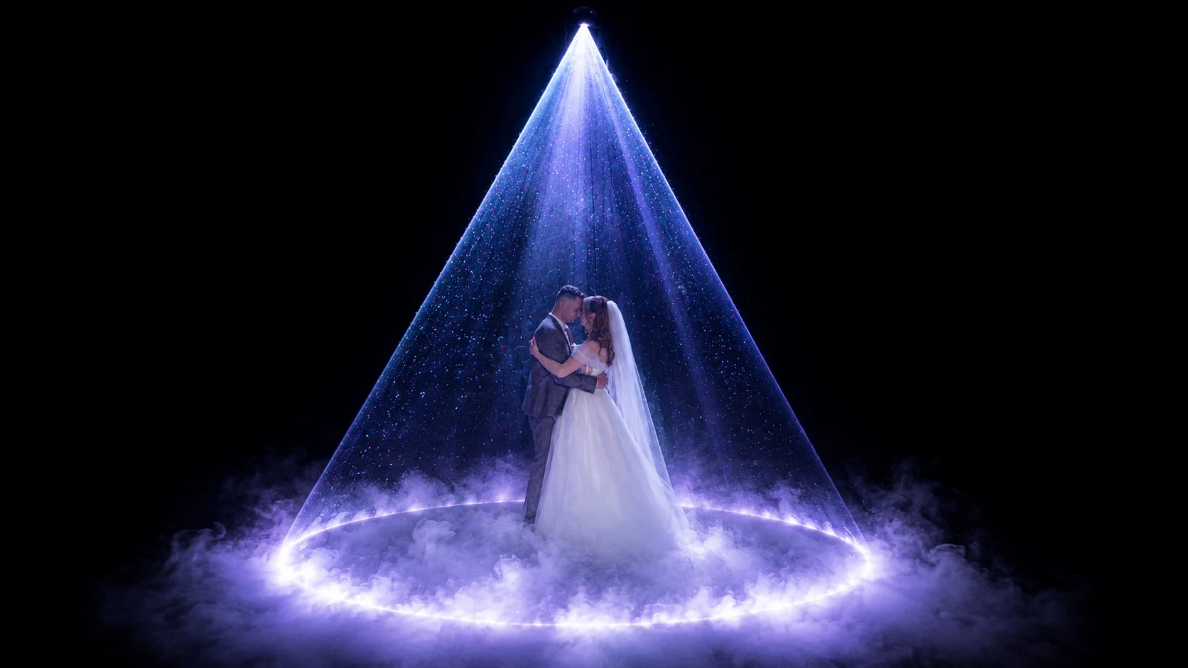 A couple dancing in a blue cone of light and a halo of mist, Cinderella effect presented by SHOW PLUS